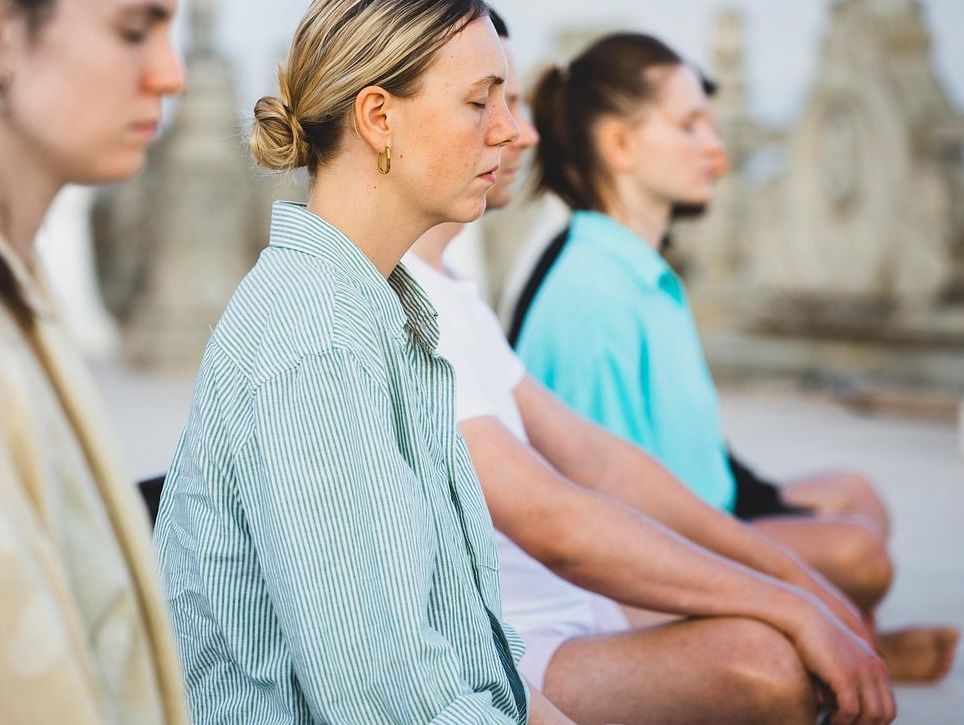Drei Frauen sitzen auf dem Boden und meditieren