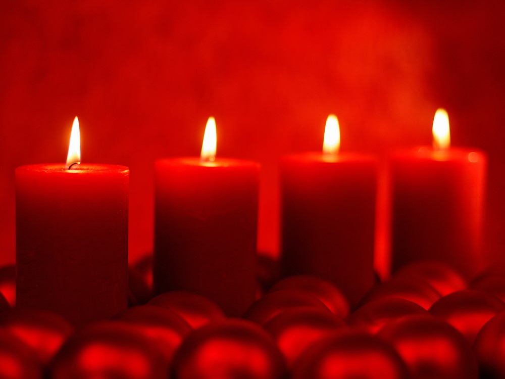 Vier brennende rote Kerzen