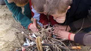 Kinder versuchen, ein Feuer mit Ästen zu entfachen