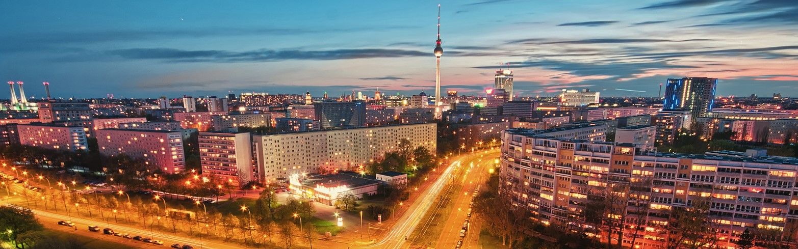 Berlin in der Abenddämmerung mit dem markanten Fernsehturm am Alexanderplatz und beleuchteten Straßen