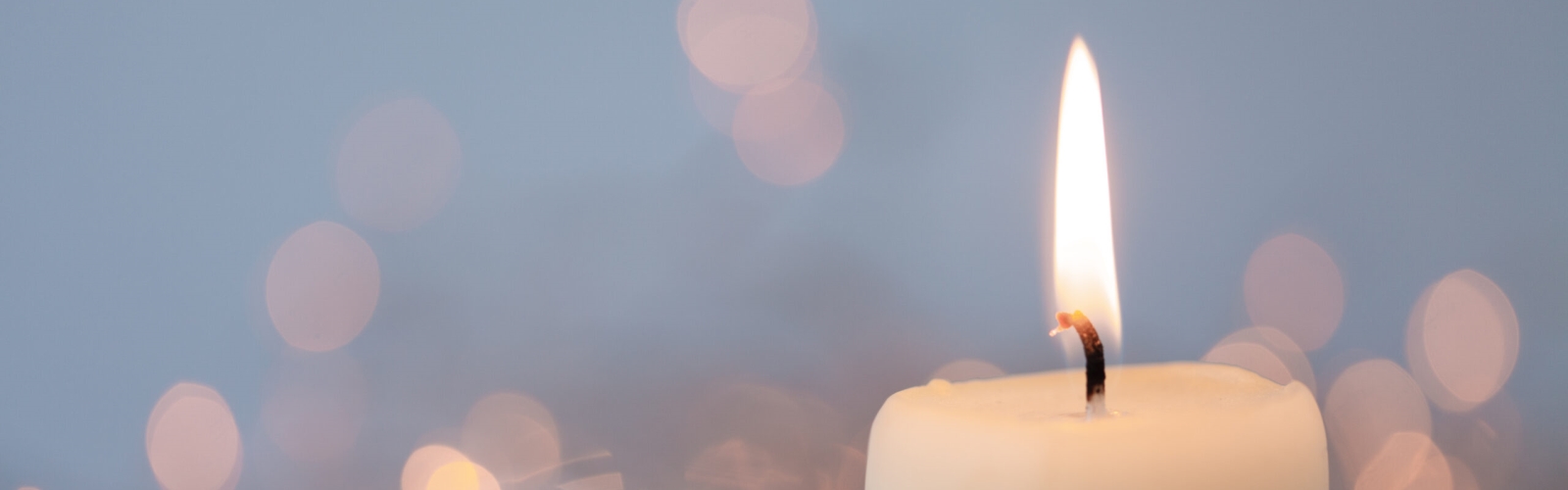 Brennende Kerze von Lichtpunkten umgeben