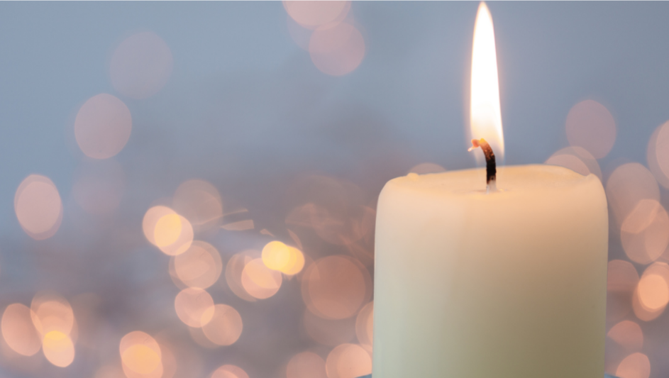 Brennende weiße Kerze mit Lichtpunkten